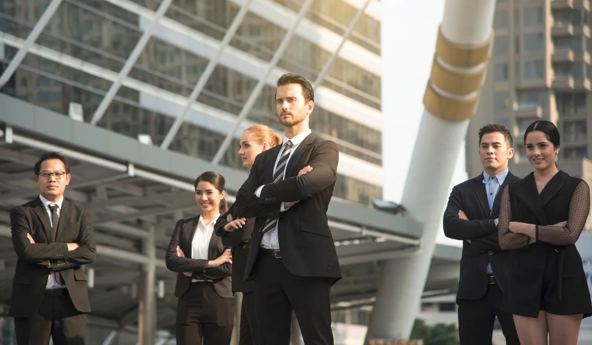 A group of diverse business leaders demonstrating transformational leadership in a modern urban setting.